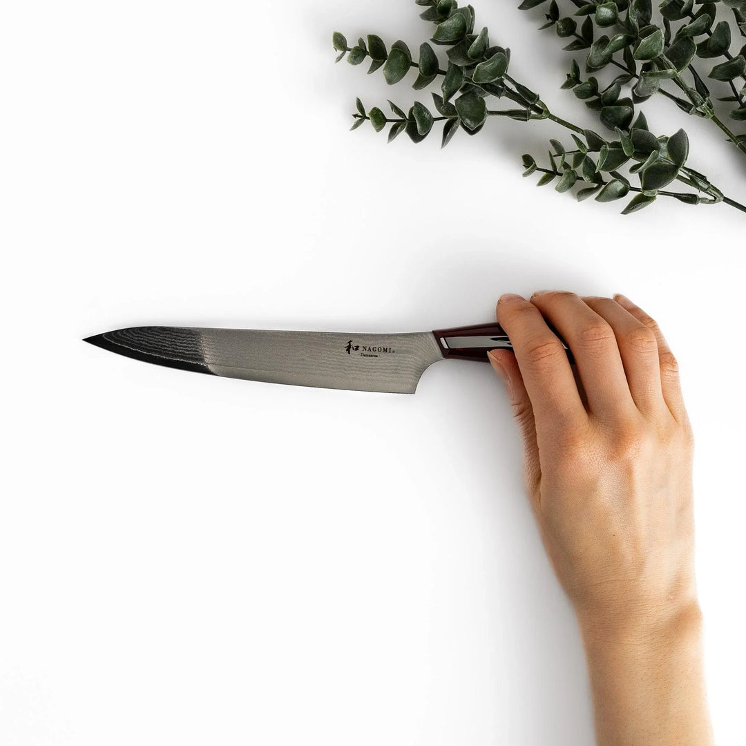 Nagomi Damascus utility knife with patterned blade and striped wooden handle offering precise everyday cutting.