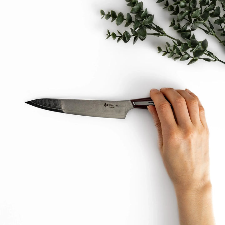 Nagomi Damascus utility knife with patterned blade and striped wooden handle offering precise everyday cutting.