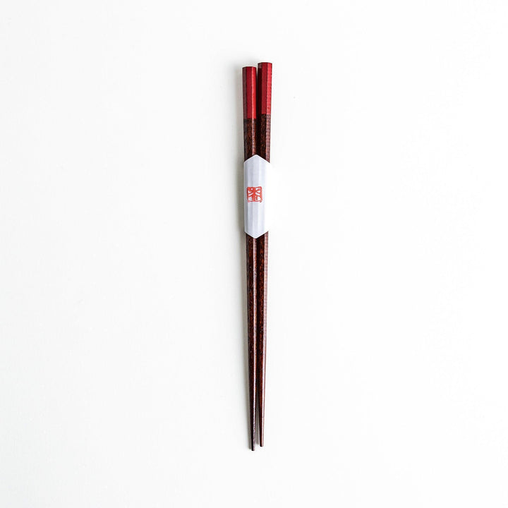 Lacquered chopsticks pair with octagonal minimalist design for sleek functional dining in green or red.
