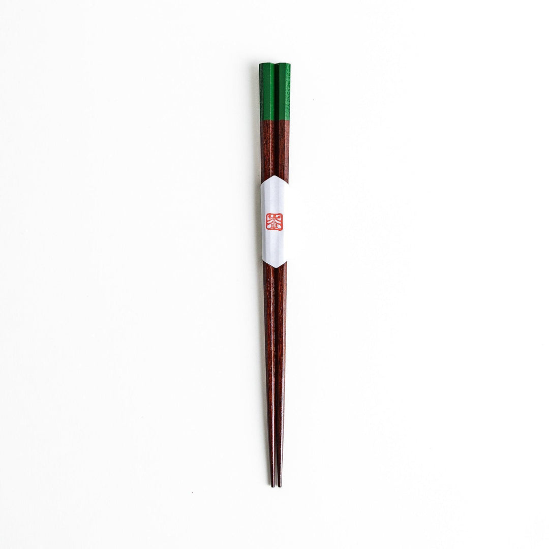 Lacquered chopsticks pair with octagonal minimalist design for sleek functional dining in green or red.