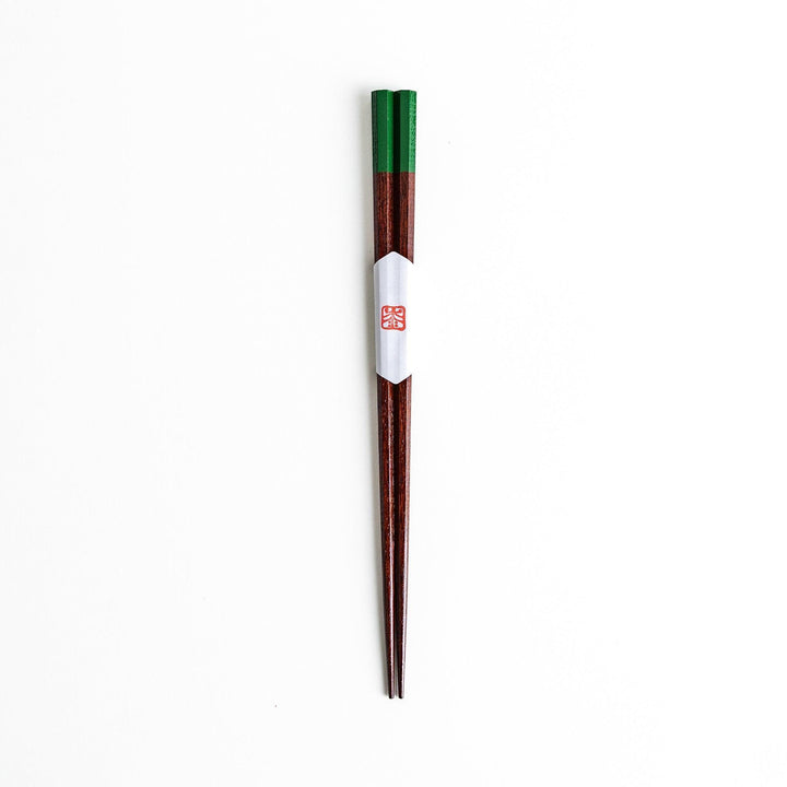 Lacquered chopsticks pair with octagonal minimalist design for sleek functional dining in green or red.