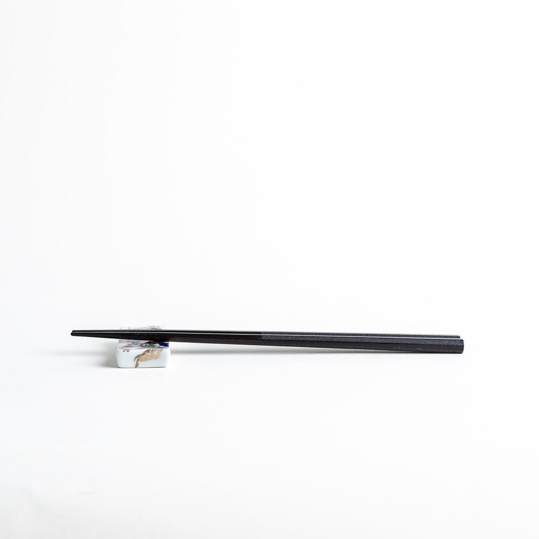 Octagonal wooden chopsticks with a brown tone, finished with a textured grain. Available in red or black.