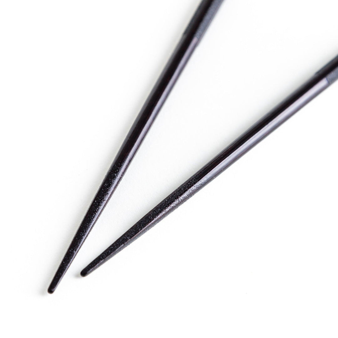 Octagonal wooden chopsticks with a brown tone, finished with a textured grain. Available in red or black.