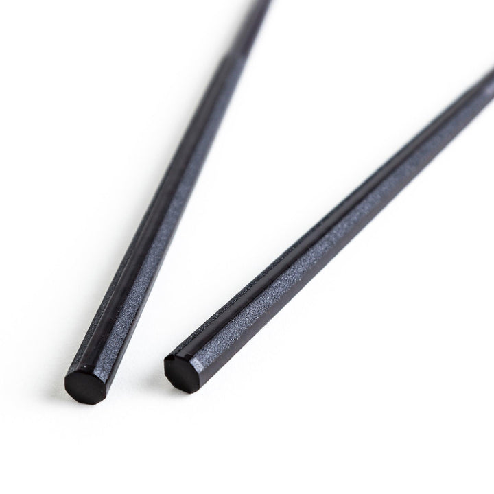 Octagonal wooden chopsticks with a brown tone, finished with a textured grain. Available in red or black.