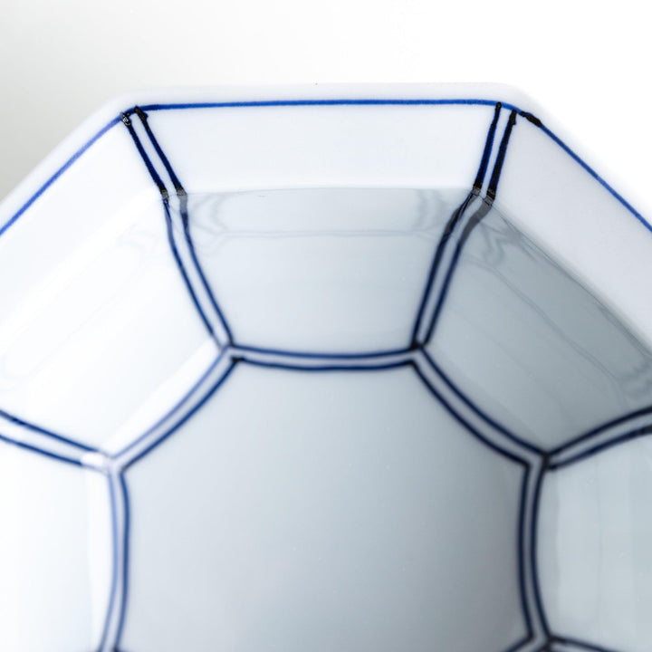 An octagonal porcelain cereal bowl with a minimalist grid pattern