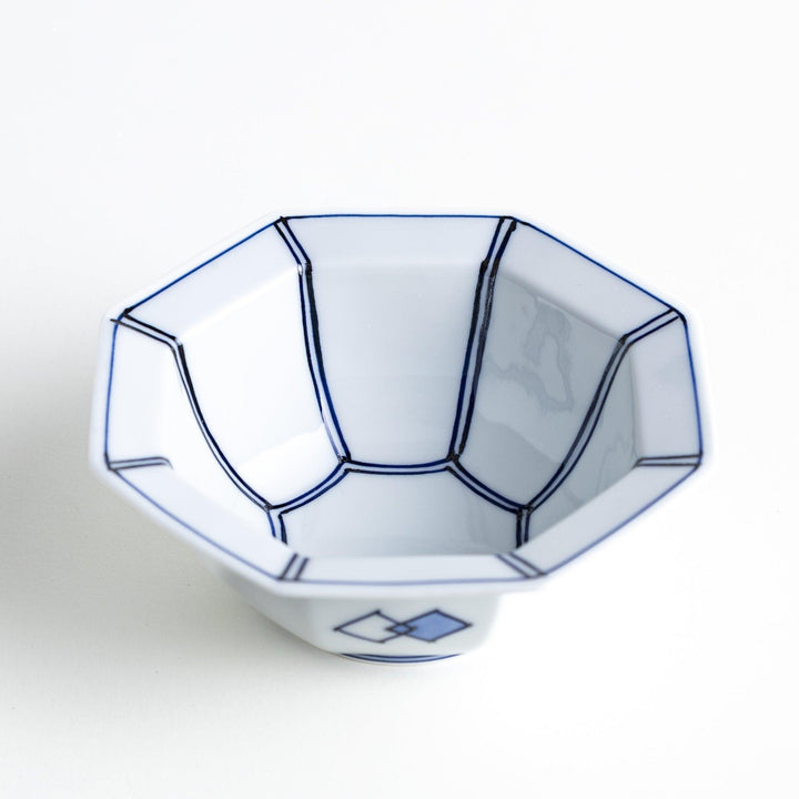 An octagonal porcelain dessert bowl with a minimalist grid pattern.