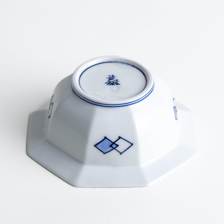 An octagonal porcelain dessert bowl with a minimalist grid pattern.