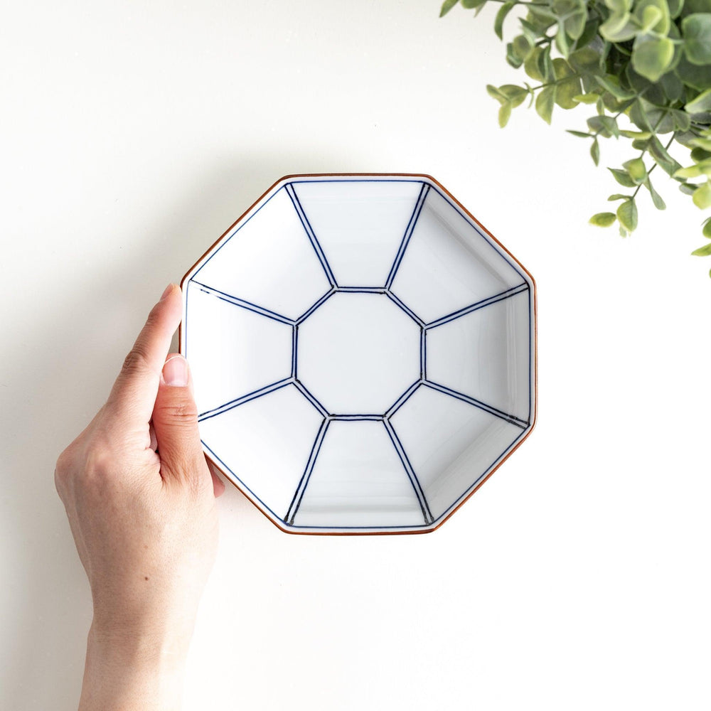 An octagonal porcelain dessert plate with a minimalist grid pattern.