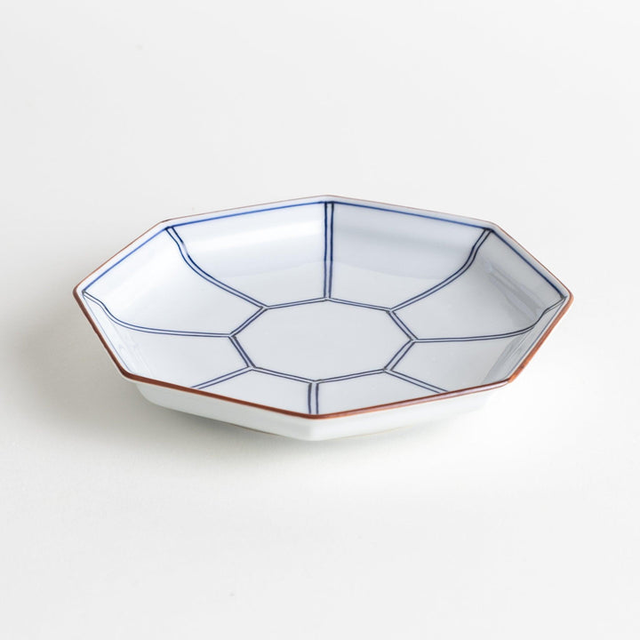 An octagonal porcelain dessert plate with a minimalist grid pattern.