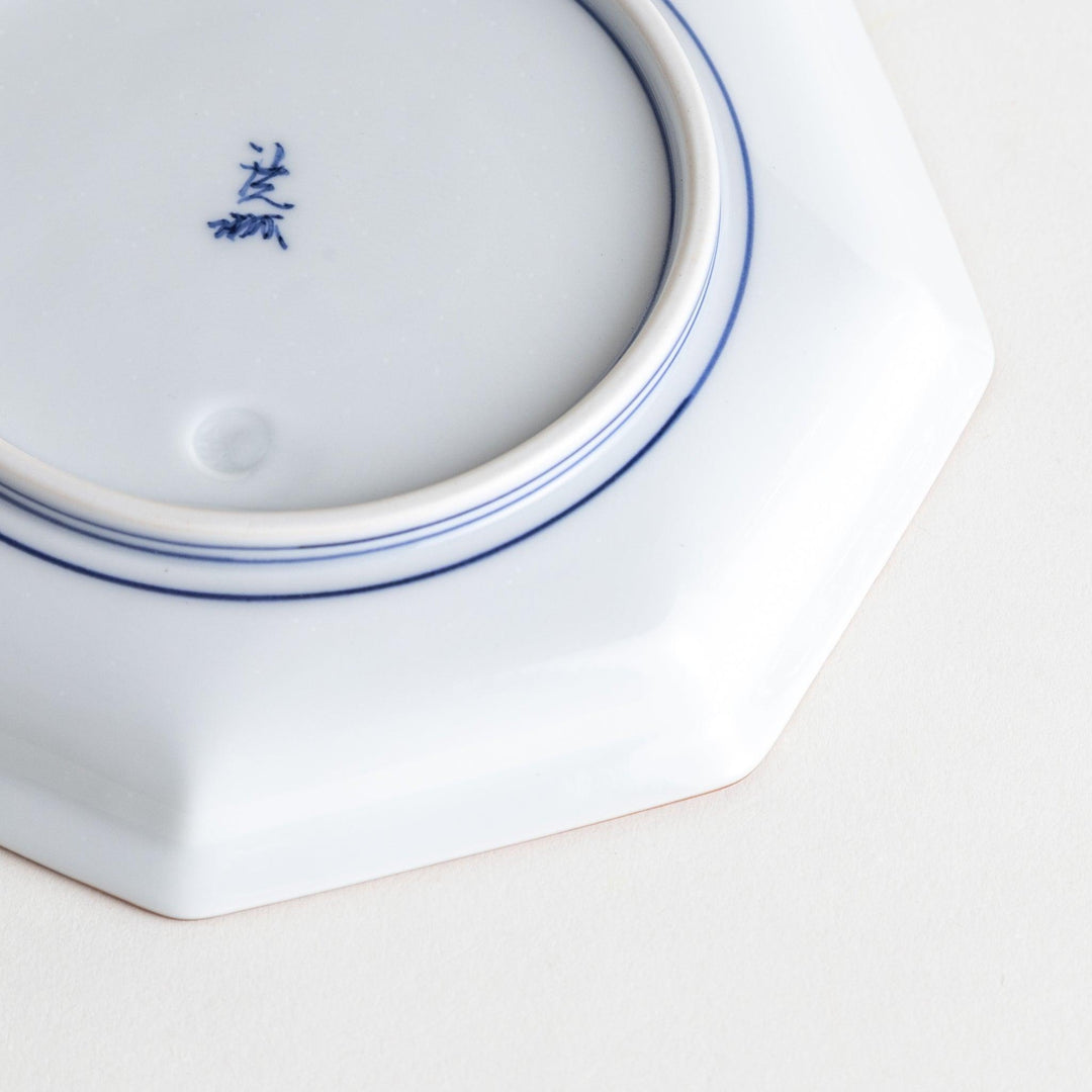 An octagonal porcelain dessert plate with a minimalist grid pattern.