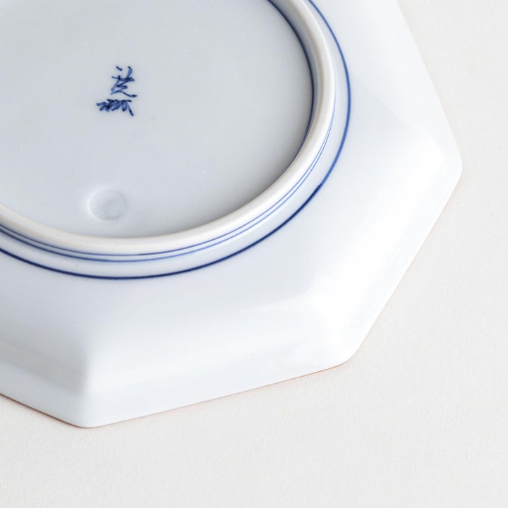 An octagonal porcelain dessert plate with a minimalist grid pattern.