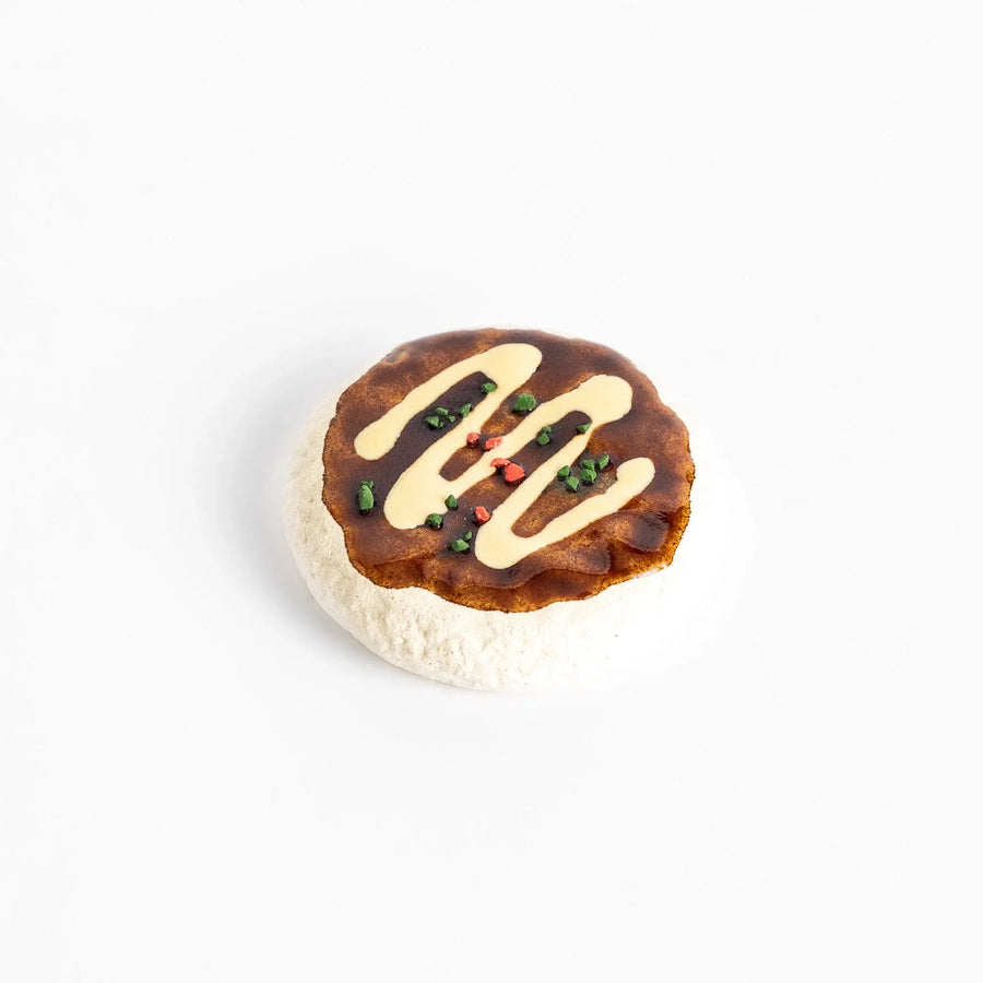 Fun Okonomiyaki-shaped chopstick rest with realistic details, including drizzled sauce and colorful toppings.