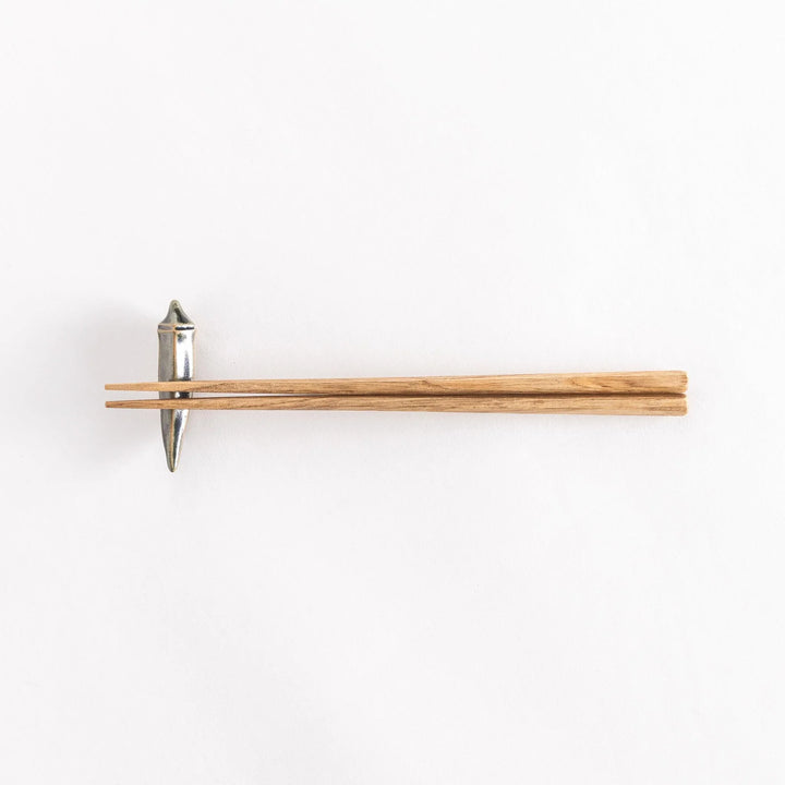 Full view of chopsticks placed on the okra-shaped rest.