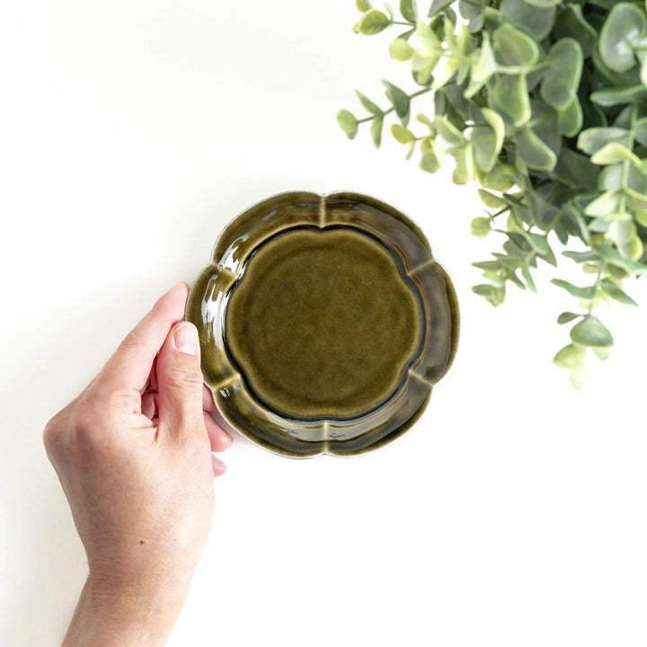 Small flower-shaped sauce dish in green, brown, and white.