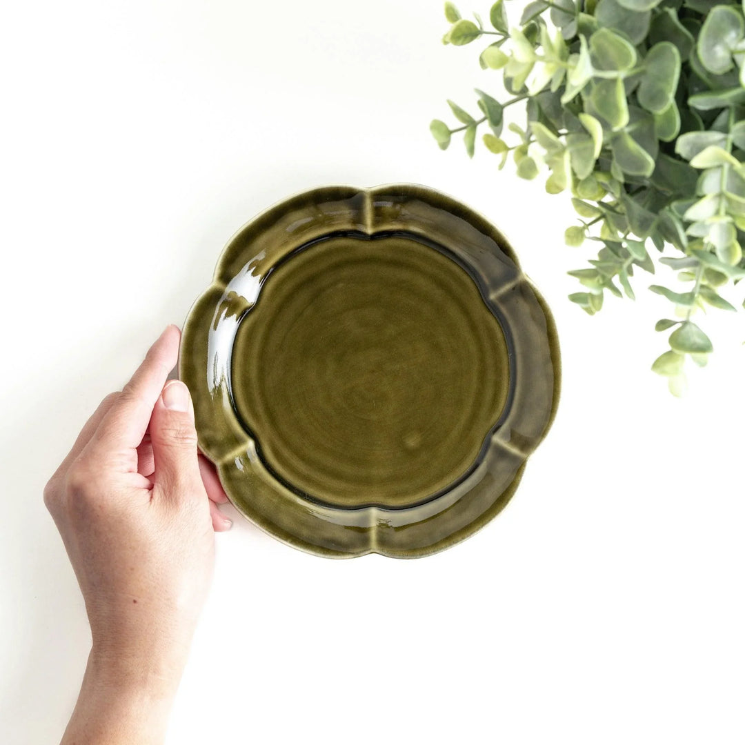 Earthy tones of olive, caramel, or off-white dessert plate, with a soft, rounded shape and subtle color variations.