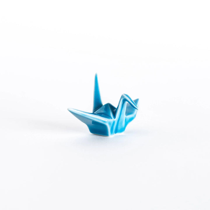 Front view of the light blue ceramic crane-shaped chopstick rest showing its refined folds.