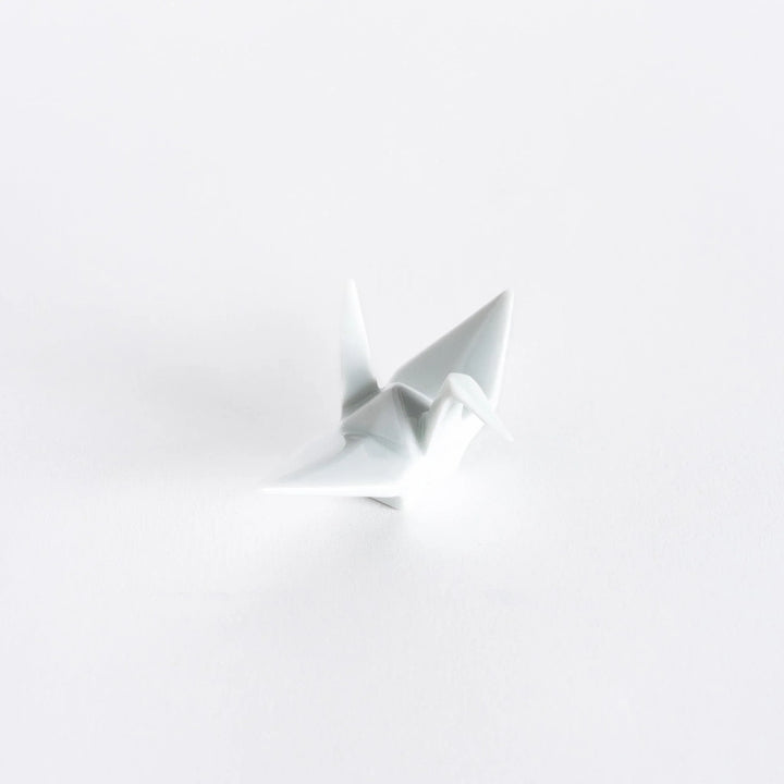 A white ceramic crane-shaped chopstick rest on a white background.