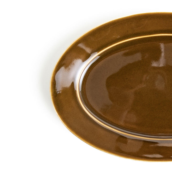 Sleek, dark brown or olive colored oval dinner plate with a glossy finish, simple and minimalist.