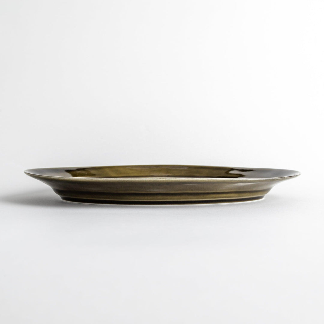 Sleek, dark brown or olive colored oval dinner plate with a glossy finish, simple and minimalist.