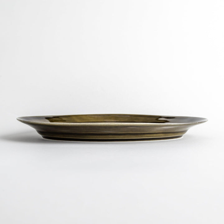 Sleek, dark brown or olive colored oval dinner plate with a glossy finish, simple and minimalist.