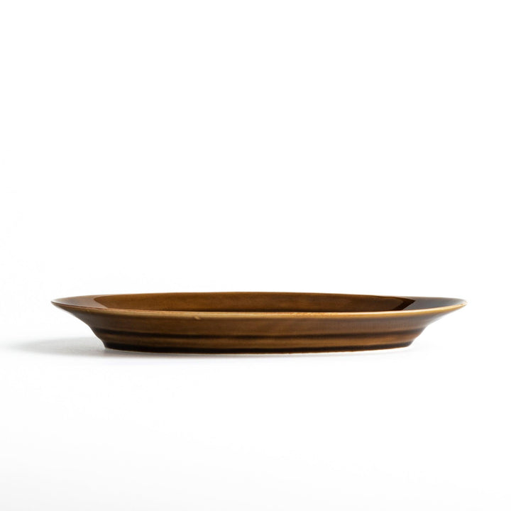 Sleek, dark brown or olive colored oval salad plate with a glossy finish, simple and minimalist.