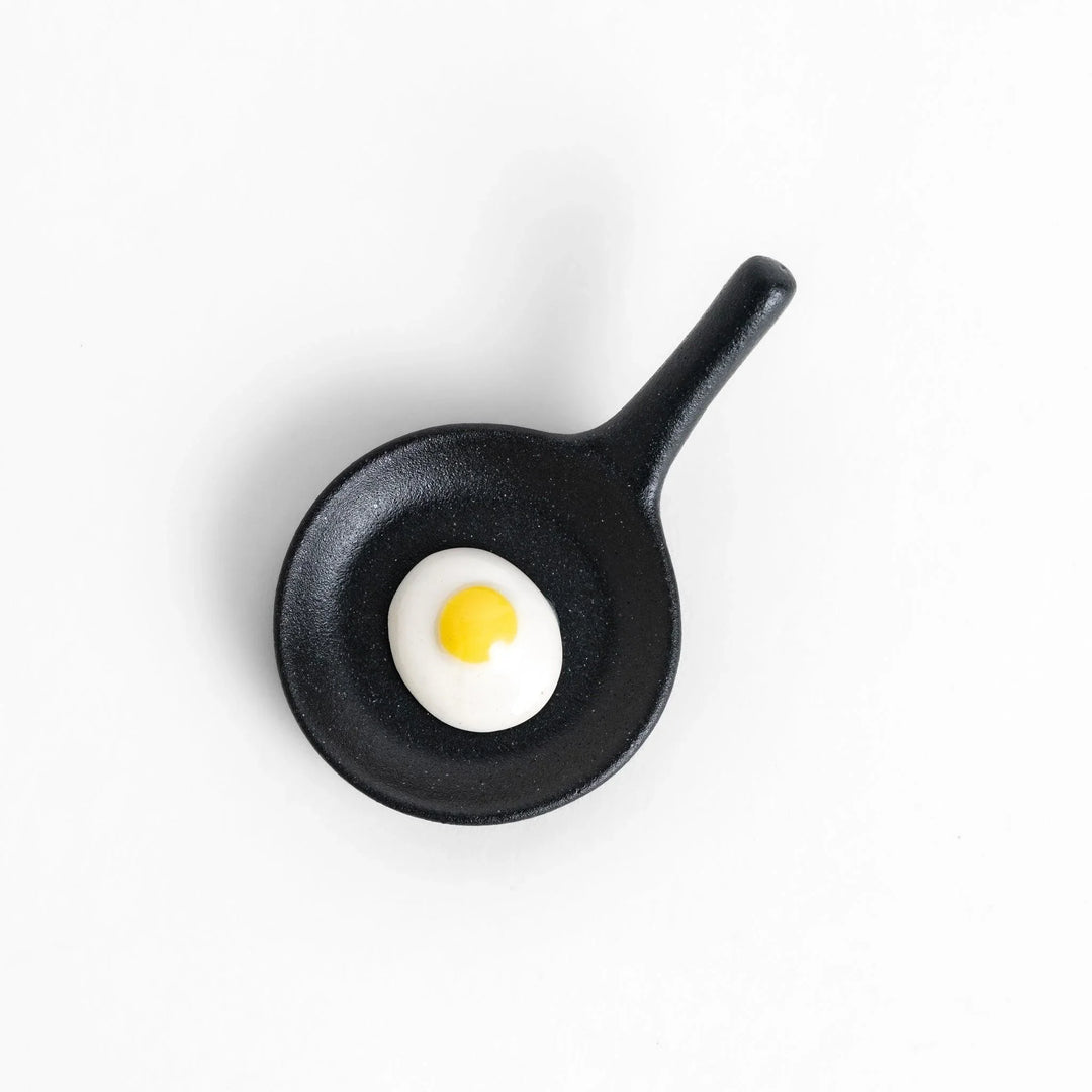 Frying pan chopstick rest with realistic fried egg design bringing playful touch to Japanese dining.