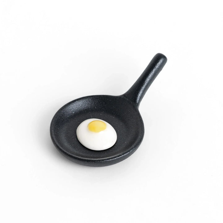 Frying pan chopstick rest with realistic fried egg design bringing playful touch to Japanese dining.
