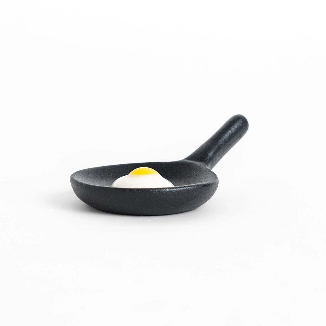 Frying pan chopstick rest with realistic fried egg design bringing playful touch to Japanese dining.