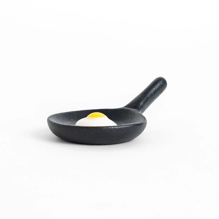 Frying pan chopstick rest with realistic fried egg design bringing playful touch to Japanese dining.