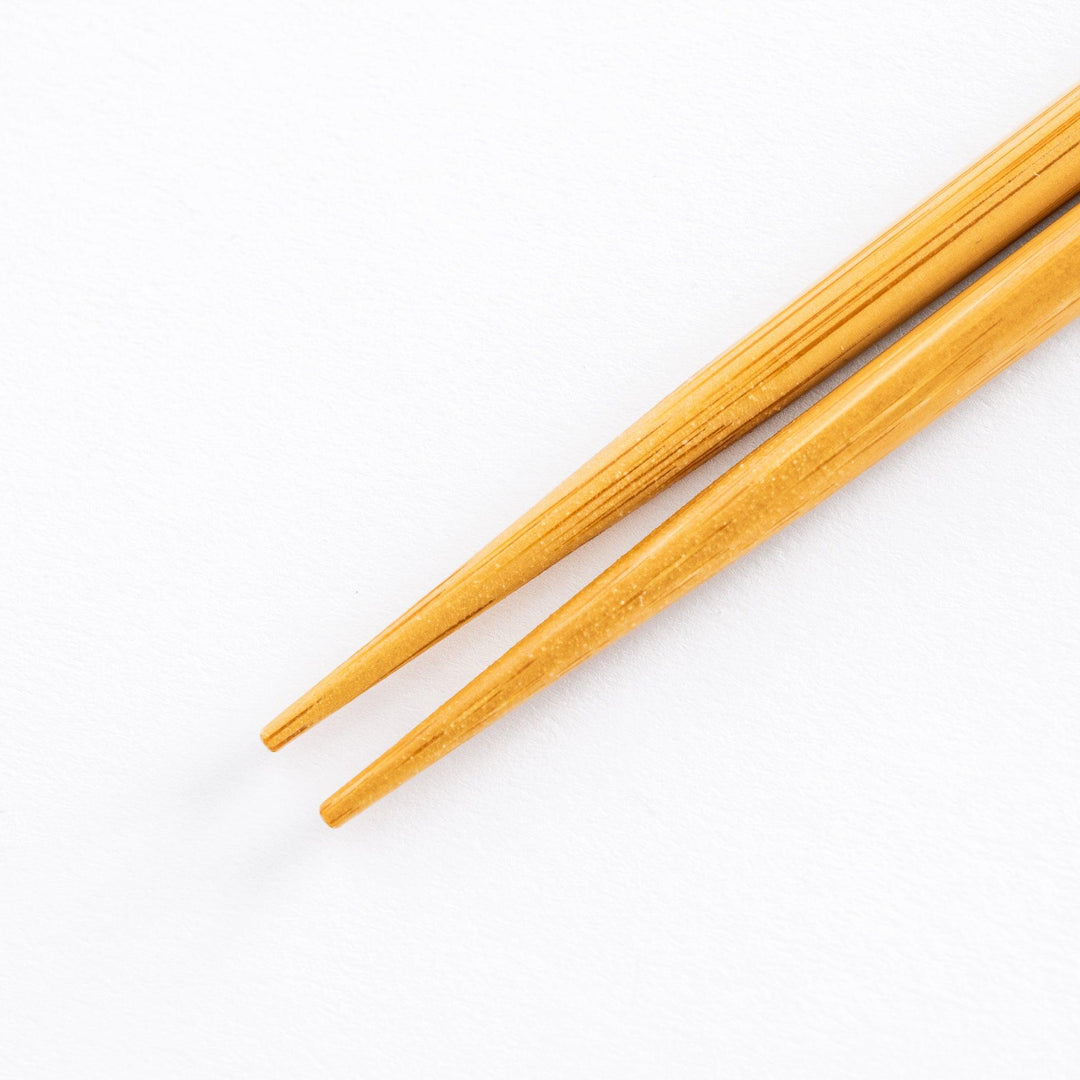Close-up of the sharp tips of beige bamboo cooking chopsticks, perfect for precise food handling.