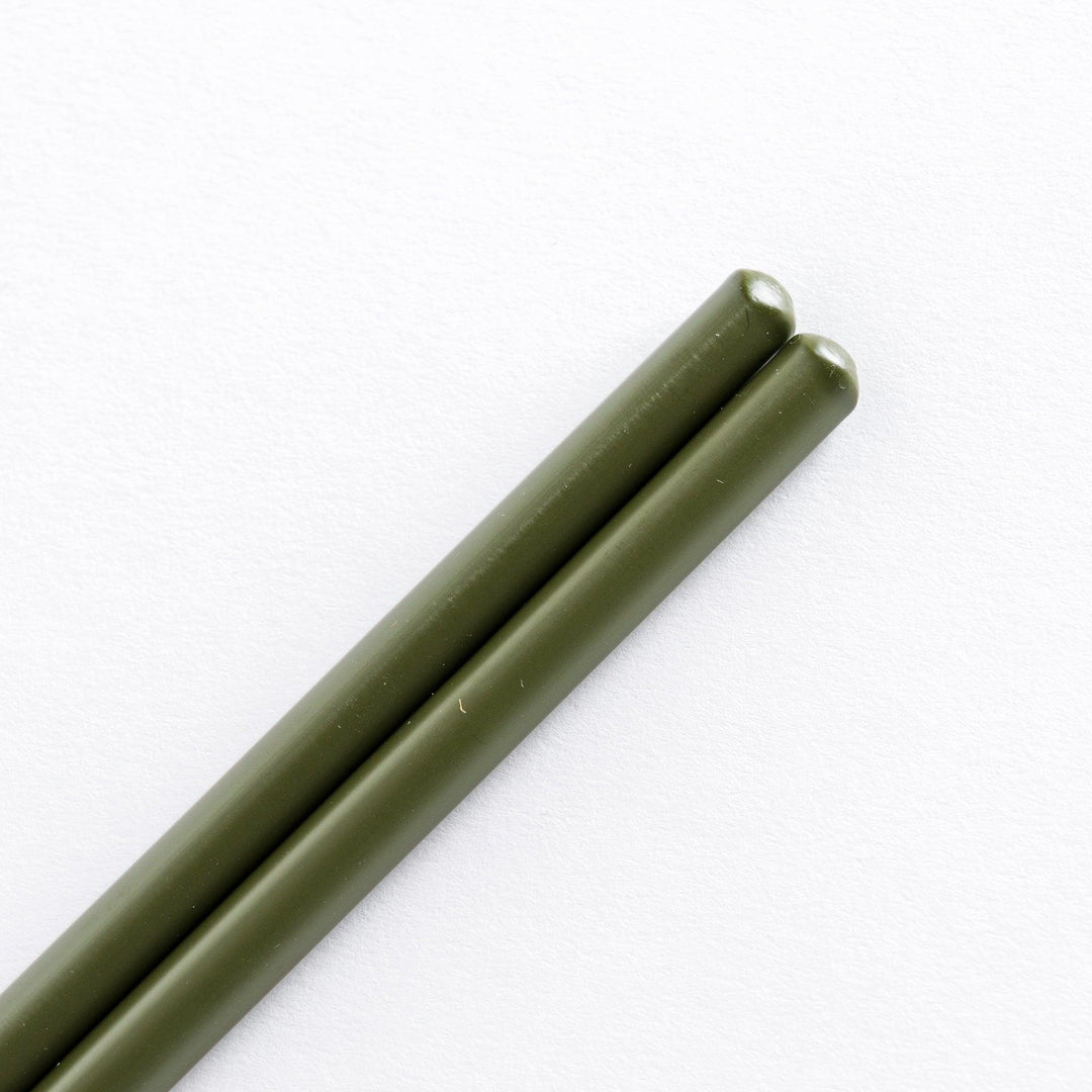 Close-up of green-tipped cooking chopsticks, focusing on the smooth transition between the green tips and bamboo shafts.