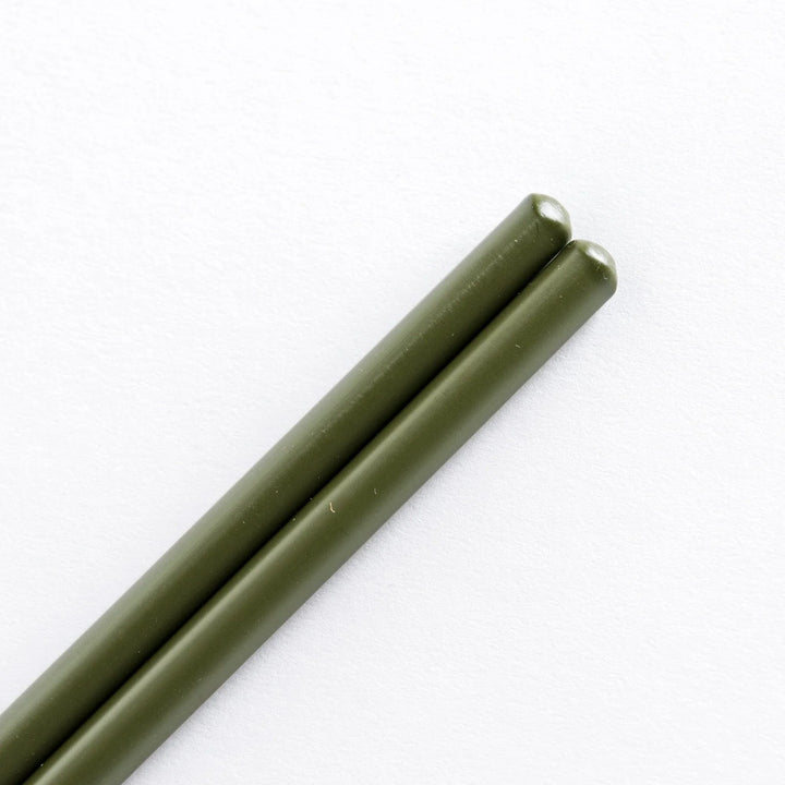 Close-up of green-tipped cooking chopsticks, focusing on the smooth transition between the green tips and bamboo shafts.
