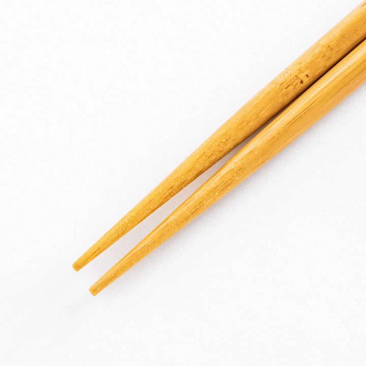 Close-up view of the bamboo tips of the cooking chopsticks, highlighting the tapered end for precision use.