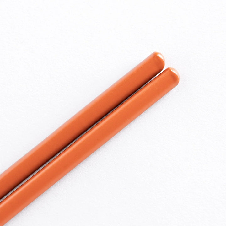 Close-up of red tips chopsticks, highlighting their smooth finish and polished design.