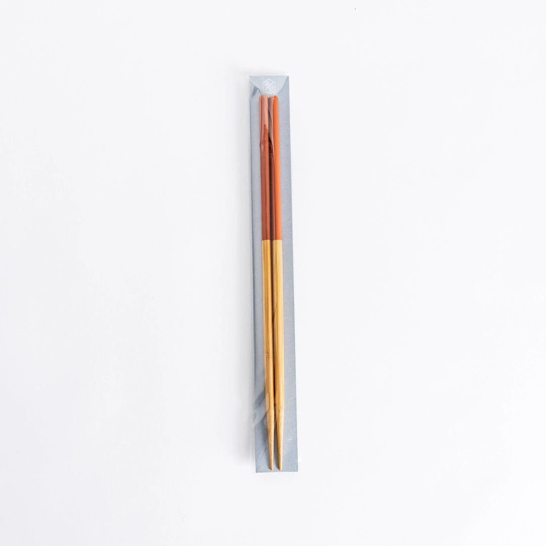 Red-tipped chopsticks in their packaging, emphasizing their attractive design.