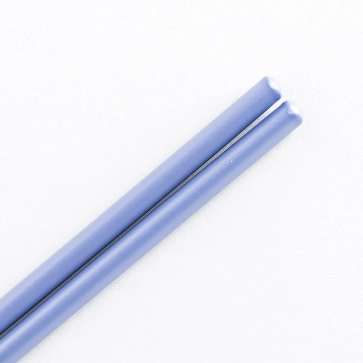 Close-up view of cooking chopsticks with smooth blue tips and bamboo shafts.