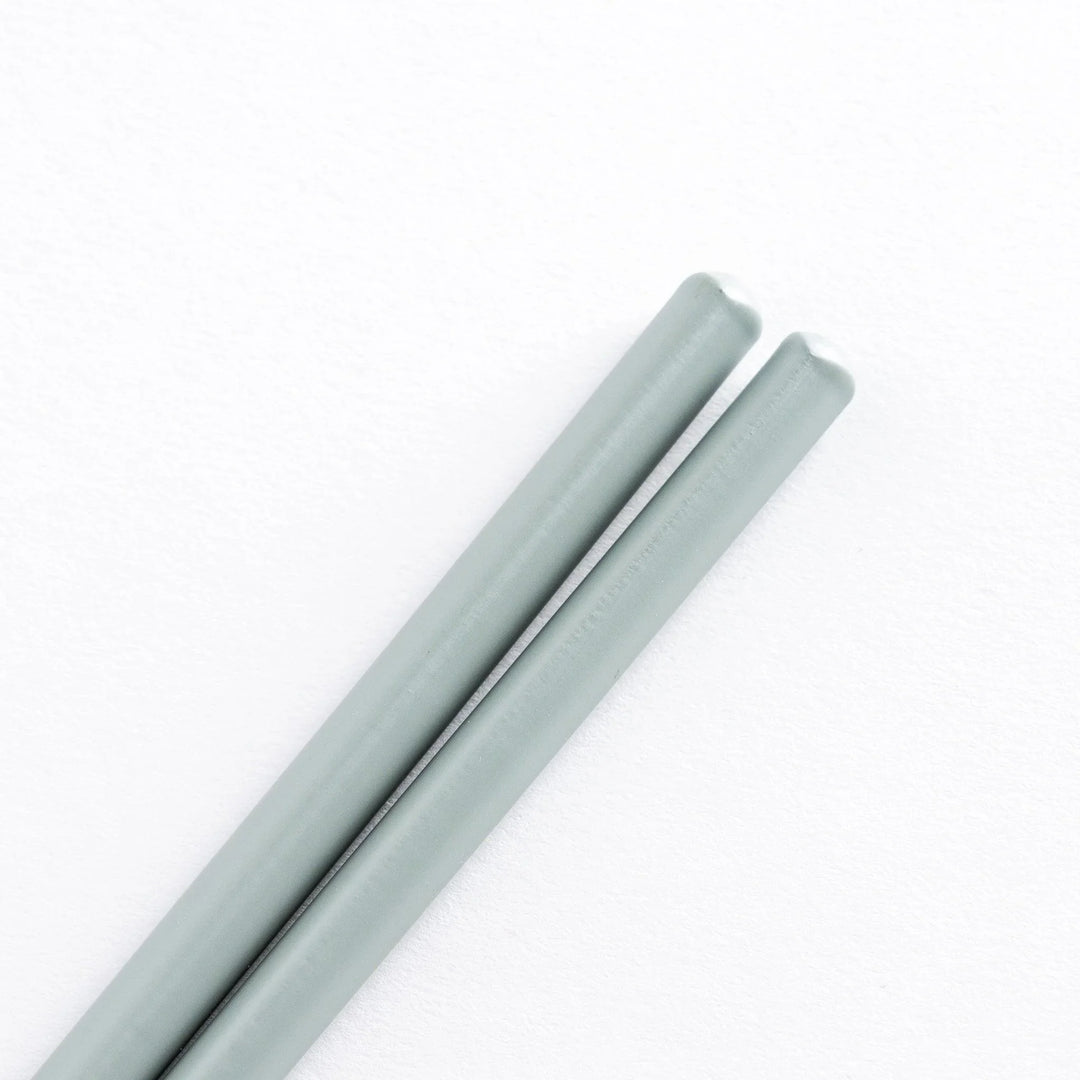 Close-up of the light gray handles of cooking chopsticks, highlighting the smooth finish.