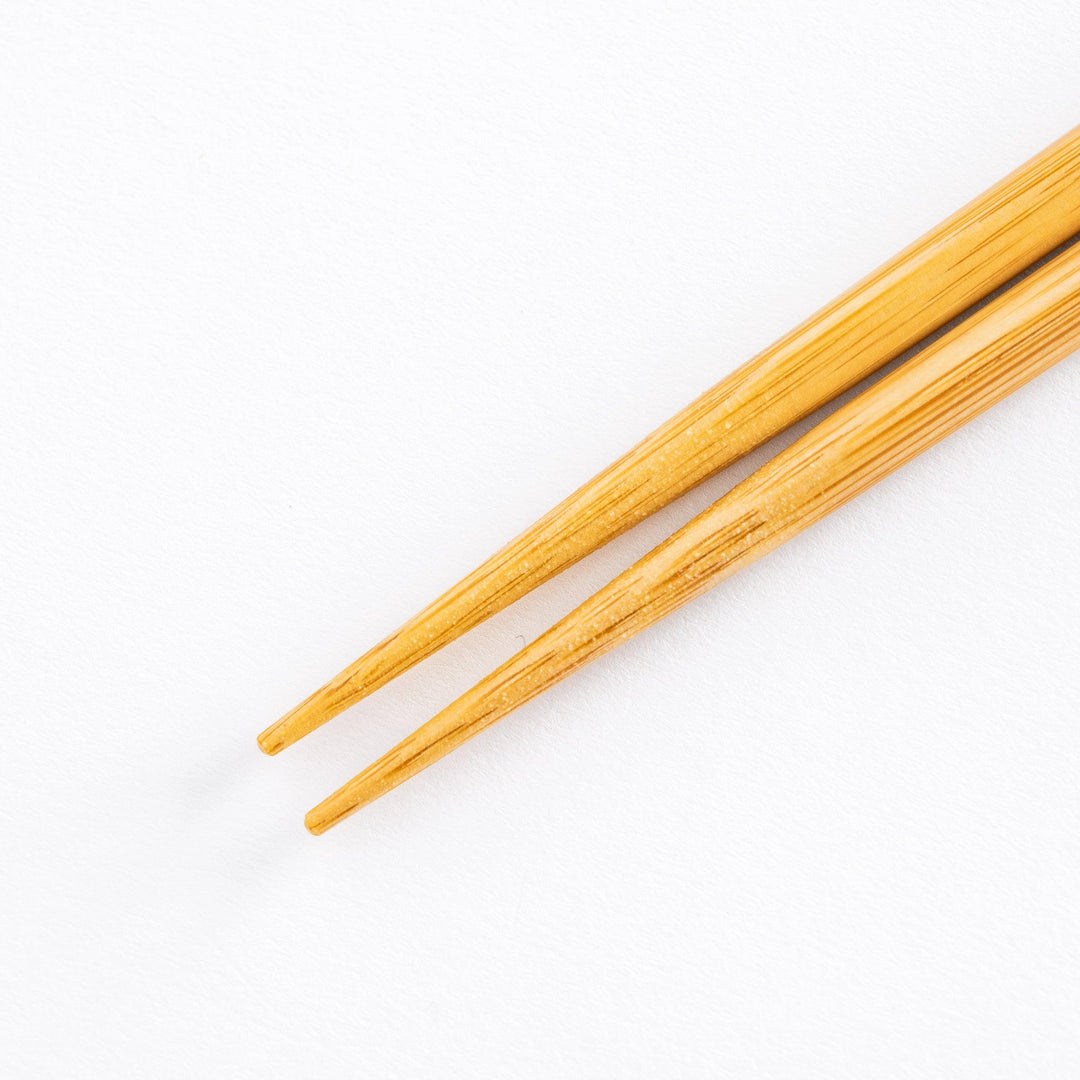 Close-up of pointed natural wood tips of cooking chopsticks.
