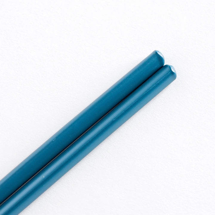 Close-up of teal-colored tips of chopsticks.