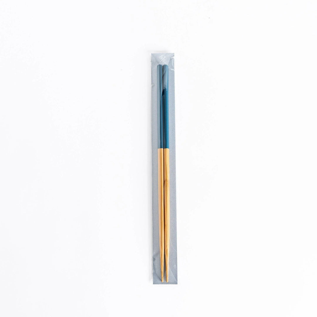 Chopsticks in packaging with teal-colored tips and bamboo body.