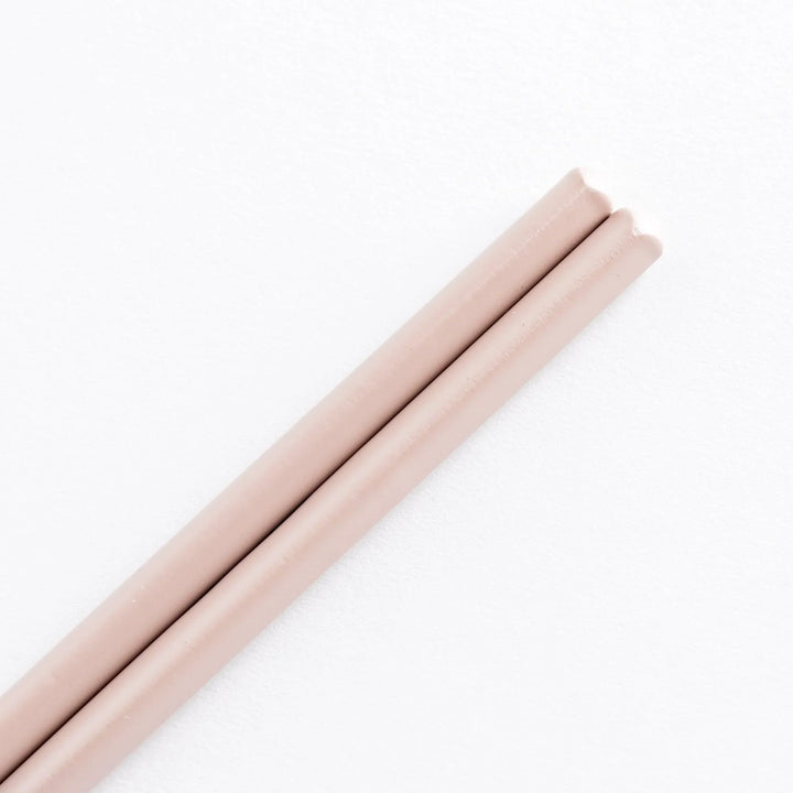 Close-up of the light pink tips of the chopsticks with bamboo detailing visible.