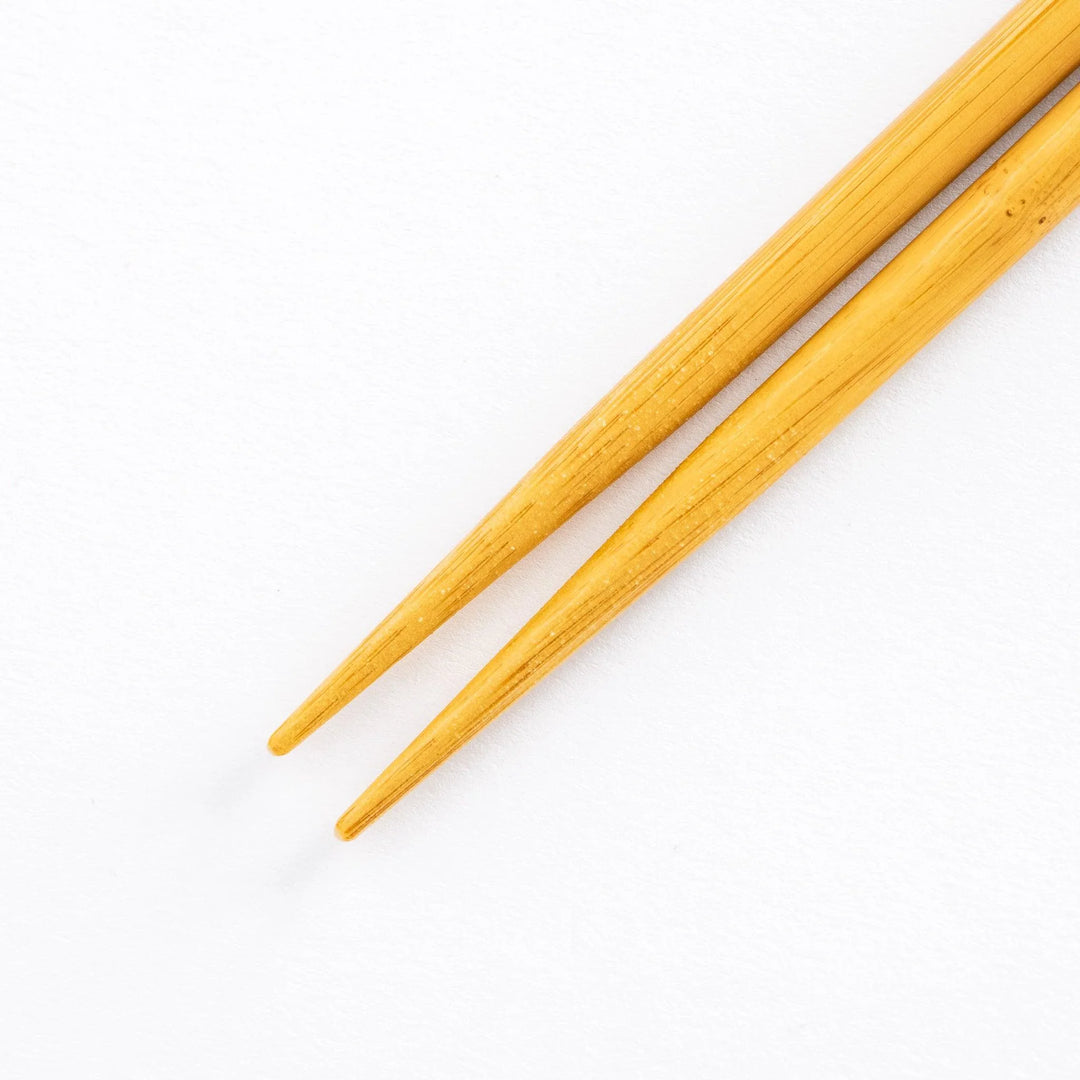 Close-up of the bamboo ends of the chopsticks, showing their tapered tips.