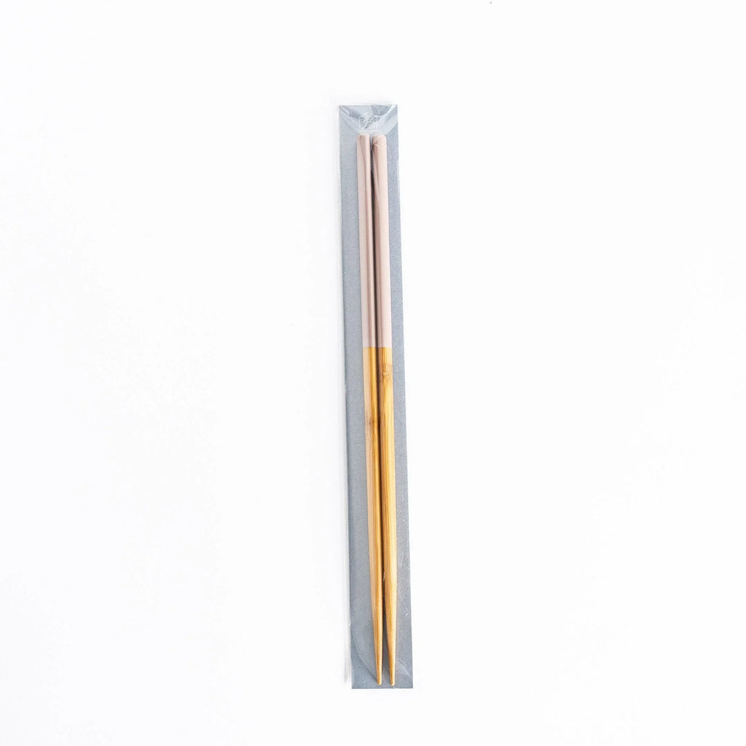 Chopsticks in their packaging, with light pink tips and bamboo finish exposed.