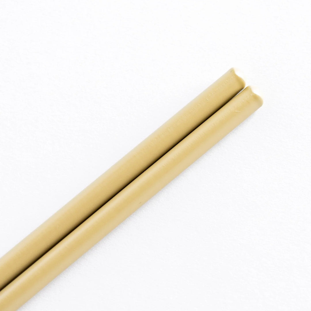 Close-up view of beige-tipped cooking chopsticks with smooth bamboo shafts.