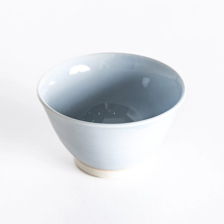 A light blue dessert bowl, photographed at a slight angle, highlighting its elegant curves and serene color.