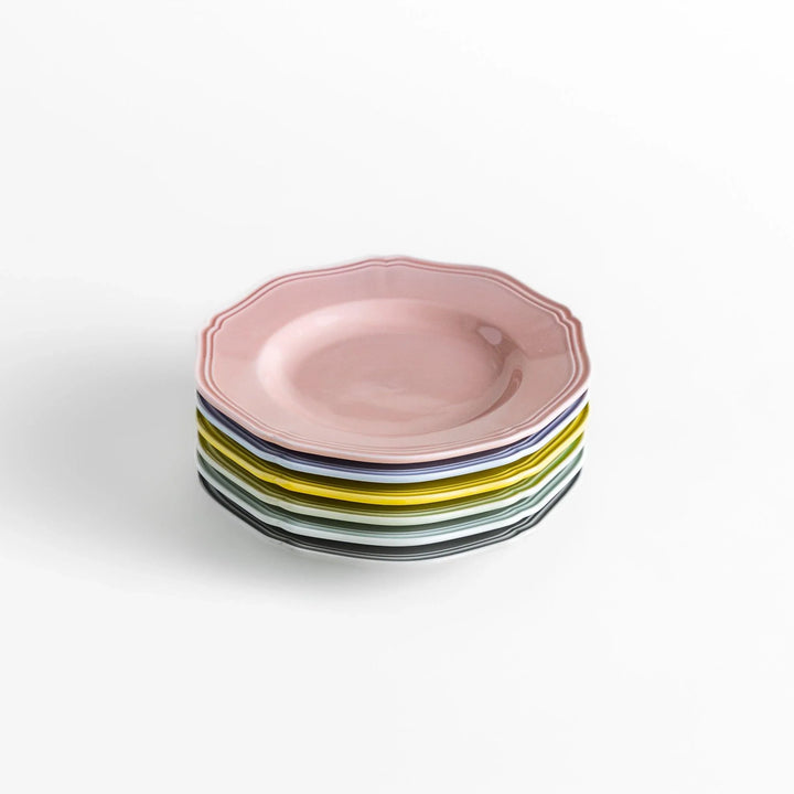 Stack of pastel Japanese ceramic dessert plates in soft hues with scalloped edges, adding charm and color to everyday dining