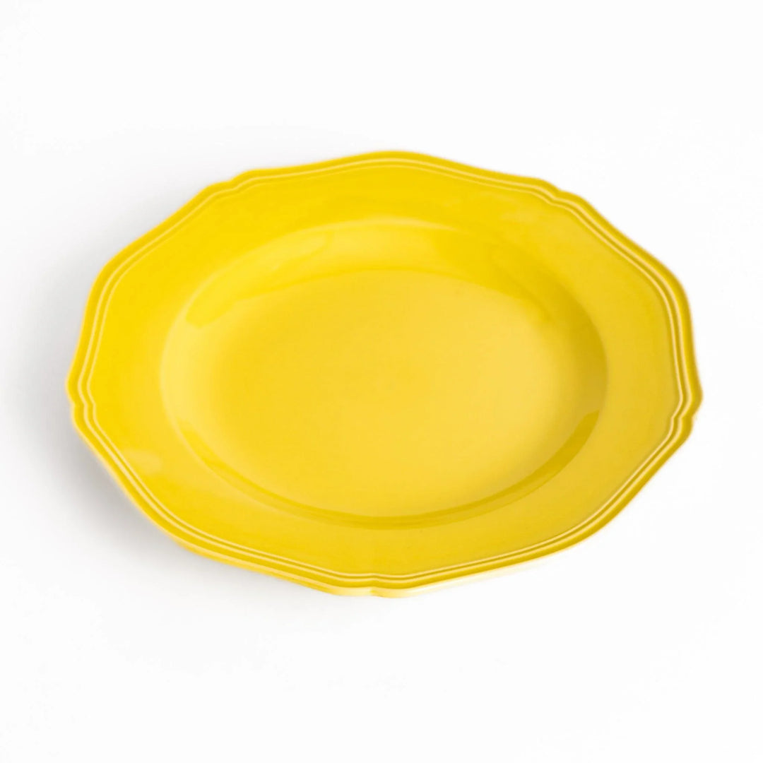 Pretty yellow dinner plate with a delicate scalloped edge, ideal for showcasing your culinary creations.