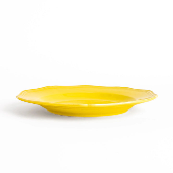 Pretty yellow dinner plate with a delicate scalloped edge, ideal for showcasing your culinary creations.