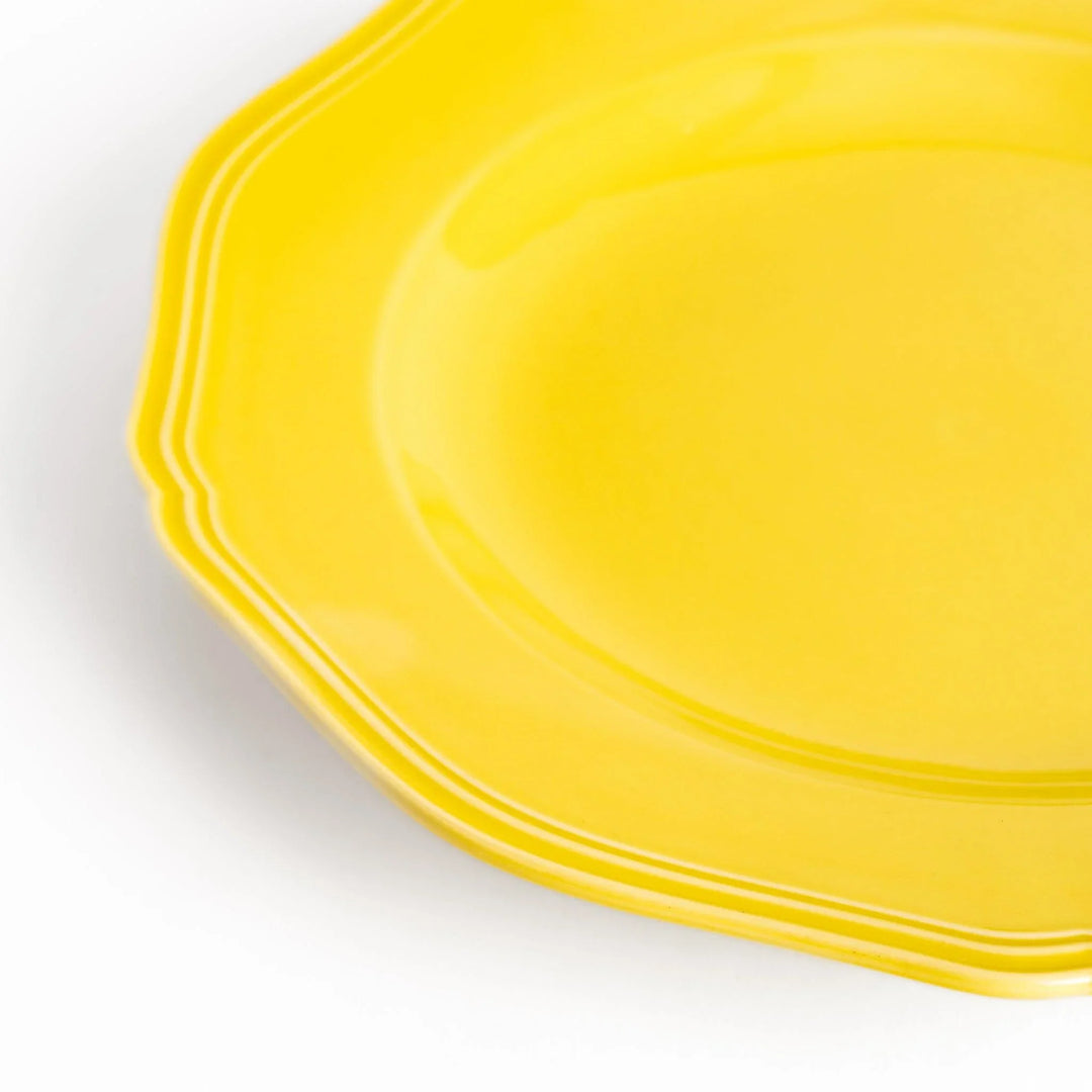 Pretty yellow dinner plate with a delicate scalloped edge, ideal for showcasing your culinary creations.