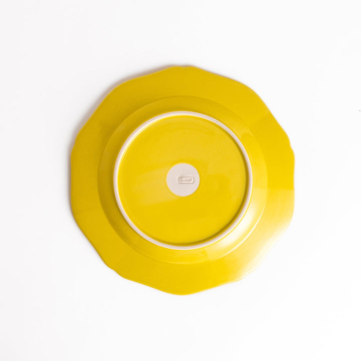 Pretty yellow dinner plate with a delicate scalloped edge, ideal for showcasing your culinary creations.